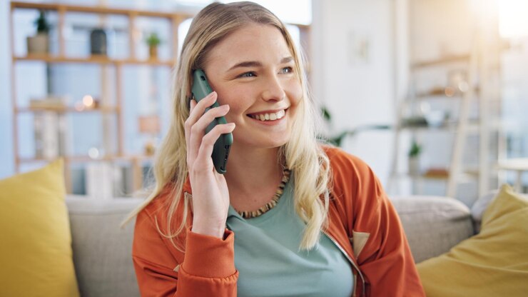 Foto glückliche frau und spricht mit telefonanruf im wohnzimmer für kommunikation netzwerk und chat auf dem sofa aufgeregt gen z mädchen lächeln mit smartphone für mobile konversation kontakt oder digitale verbindung