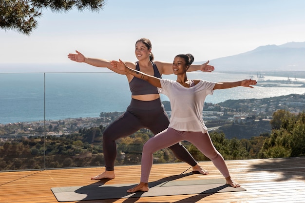 Glückliche Frauen, die Yoga auf Matte tun