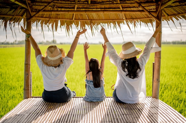 Glückliche Frauengruppe auf dem Sonnenuntergang in der Natur im Sommer mit den offenen Händen