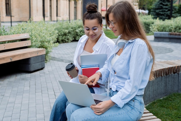 Foto glückliche freiberufler diskutieren arbeitsprojekte, die startups planen, zeigen auf dem bildschirm zwei mädchenfrauen