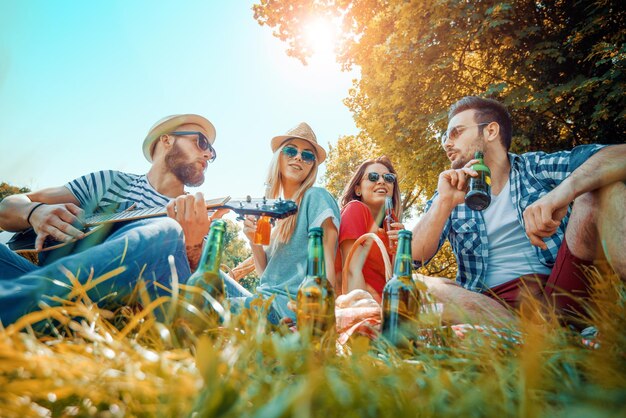 Foto glückliche freunde beim picknick im park