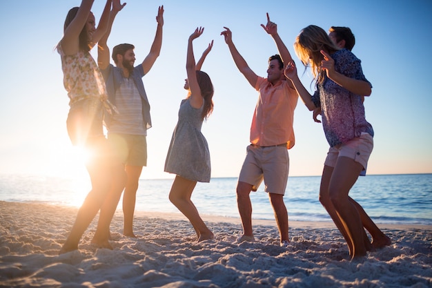 Glückliche Freunde, die auf den Sand tanzen