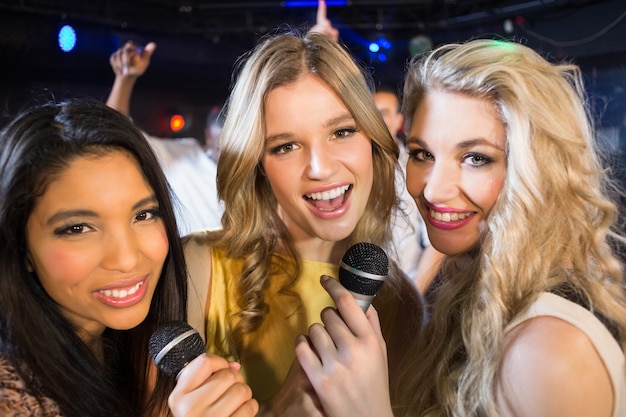 Glückliche Freunde, die beim Karaoke singen