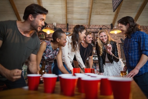 Glückliche Freunde, die Bier-Pong-Spiel in der Bar spielen