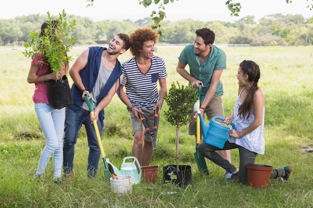 Glückliche Freunde, die für die Gemeinschaft im Garten arbeiten