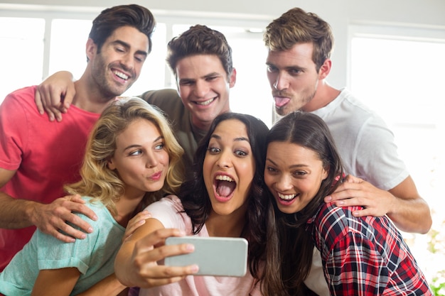 Glückliche Freunde, die Gesichter beim selfie zu Hause nehmen machen