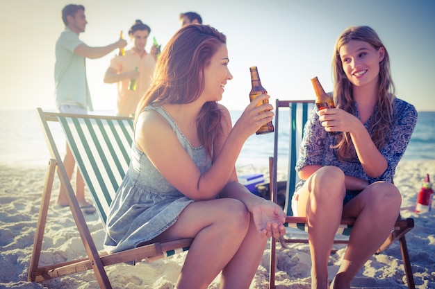 Glückliche Freunde, die Grill tun und Bier trinken