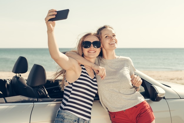 Glückliche Freunde, die selfie im Auto nehmen