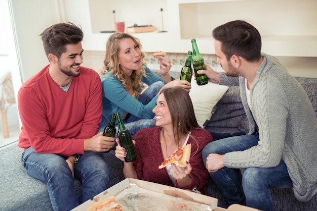 Glückliche Freunde, die zu Hause Pizza essen