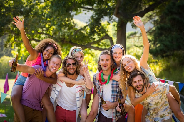 Glückliche Freunde, die zusammen auf Campingplatz posieren