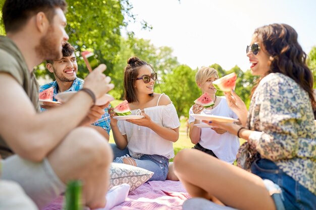 Foto glückliche freunde essen wassermelonen beim sommerpicknick