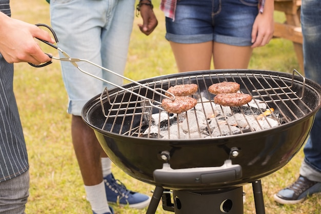 Glückliche Freunde im Park, der Grill hat