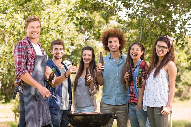 Glückliche Freunde im Park, der Grill hat