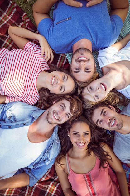 Glückliche Freunde im Park, der in cirlce einhängt