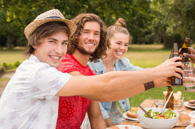 Glückliche Freunde im Park, der zu Mittag isst