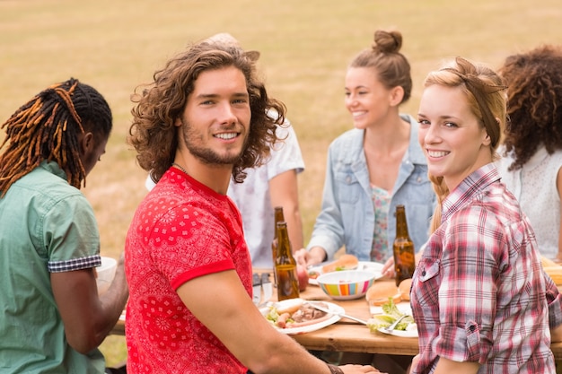 Glückliche Freunde im Park, der zu Mittag isst