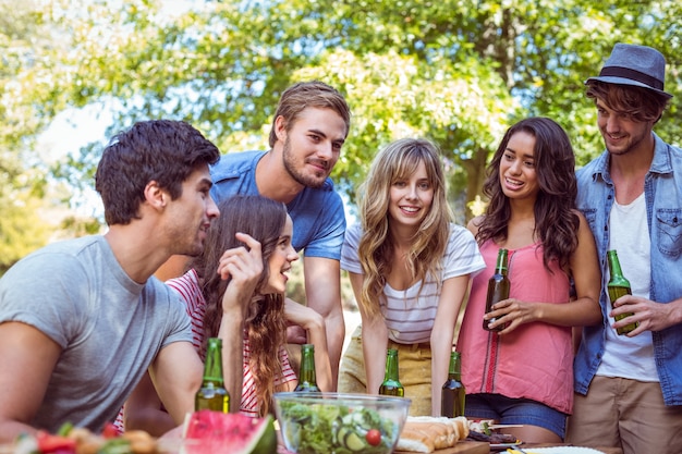 Glückliche Freunde im Park, der zu Mittag isst