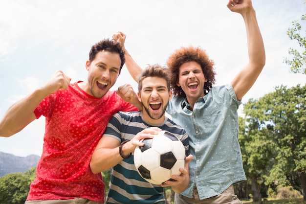 Glückliche Freunde im Park mit Fußball