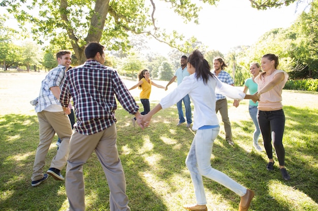 Glückliche Freunde in den Parkhändchenhalten