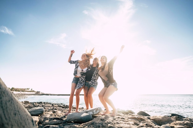 Foto glückliche freundinnen stehen an einem sonnigen tag am strand