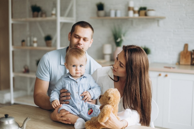 Glückliche fröhliche junge Familie zu Hause