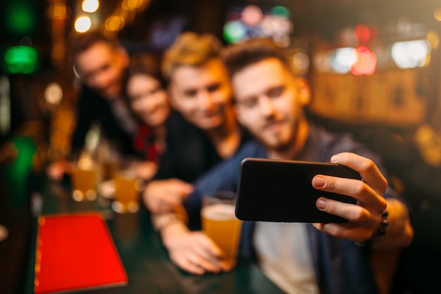 Glückliche fußballfans machen selfie an der theke