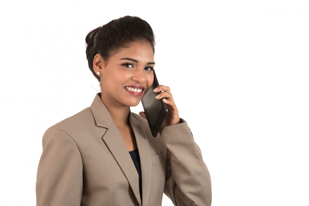 Glückliche Geschäftsfrau, die auf dem Handy oder Smartphone lokalisiert auf weißem Raum spricht