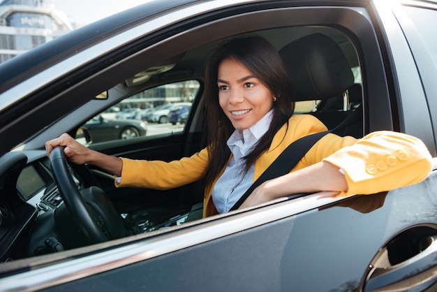 Glückliche Geschäftsfrau, die ihr neues Auto fährt