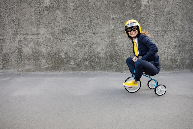 Glückliche Geschäftsfrau, die zur Arbeit geht. Lustige junge Frau, die im Freien Retro- Fahrrad reitet. Zurück zu Arbeit, Start-up und Geschäftsideenkonzept