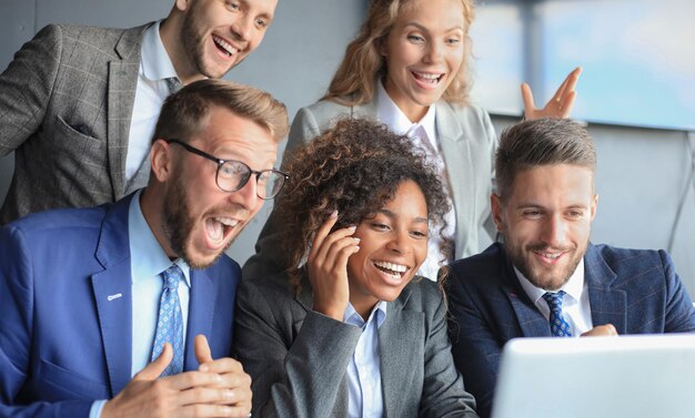 Glückliche Geschäftsleute lachen in der Nähe von Laptops im Büro Erfolgreiche Teamkollegen scherzen und haben gemeinsam Spaß bei der Arbeit