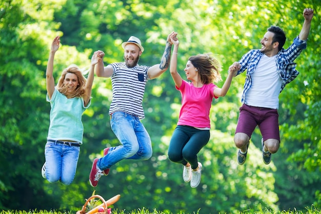 Glückliche Gruppe junger Leute, die in den Park springen