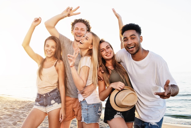 Glückliche Gruppe von Freunden, die Spaß am Strand haben