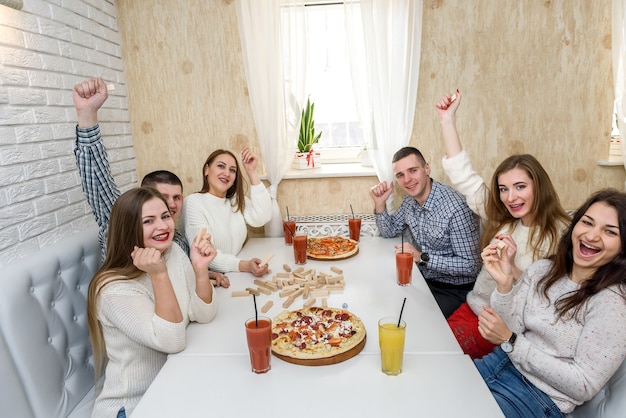 Glückliche Gruppe von Freunden im Café, die Pizza essen?