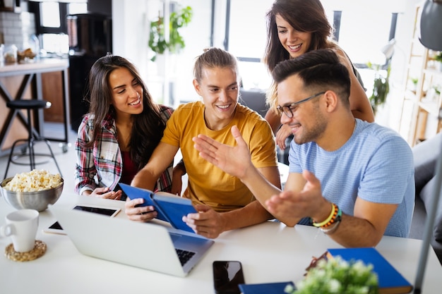 Glückliche Gruppe von Studenten, Freunden, die zusammen arbeiten und Spaß haben