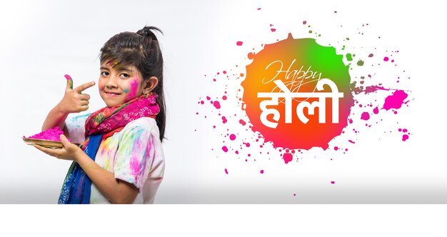 Glückliche holi-grußkarte - indische kleine kinder oder freunde oder geschwister, die das holi-fest mit gulal- oder puderfarbe, süßigkeiten, pichkari oder spray feiern