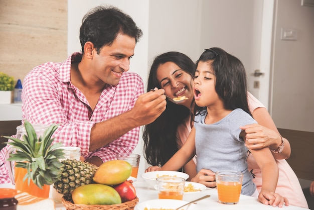 Glückliche indische asiatische junge Familie Essen zu Hause und Spaß haben. selektiver Fokus