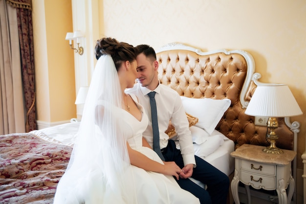 Glückliche junge Braut und Bräutigam an ihrem Hochzeitstag. Hochzeitspaar im Hotel