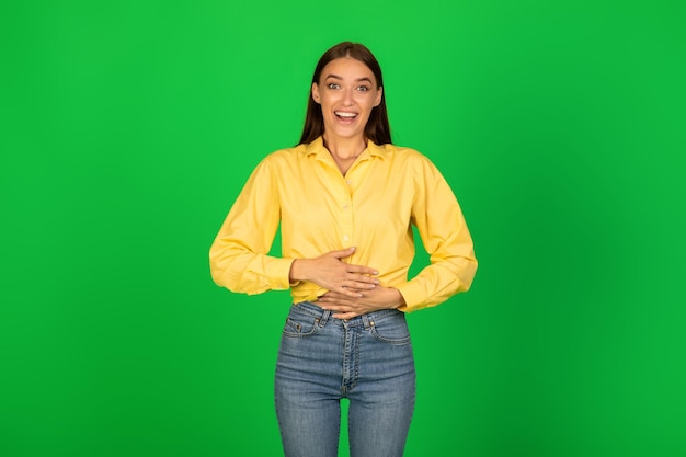 Foto glückliche junge dame, die bauch im studio berührt