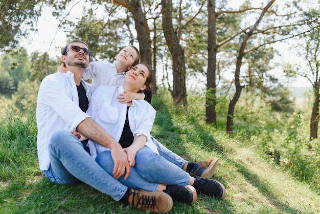 Glückliche junge Familie, die Zeit im Freien an einem Sommertag verbringt, haben Spaß am schönen Park