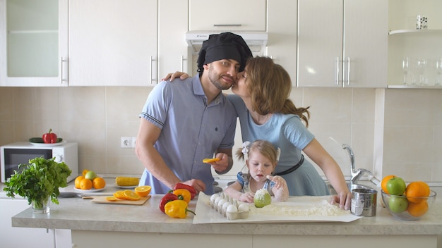 Glückliche junge Familie, die Zeit in der Küche verbringt.