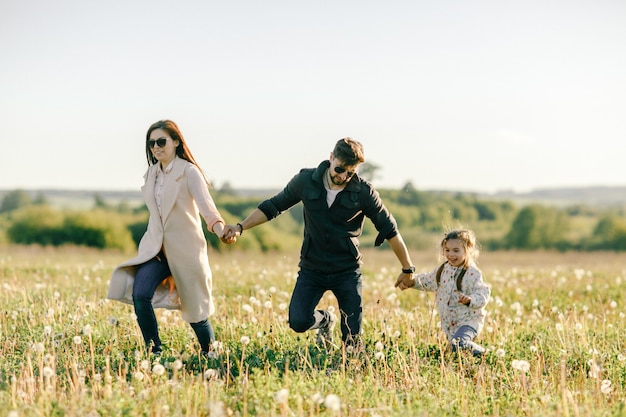 Glückliche junge Familie, die Zeit zusammen draußen in der grünen Natur verbringt