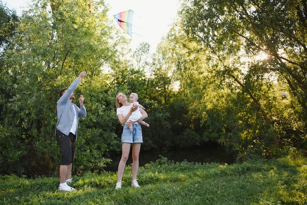 Glückliche junge Familie, die Zeit zusammen draußen in der grünen Natur verbringt.