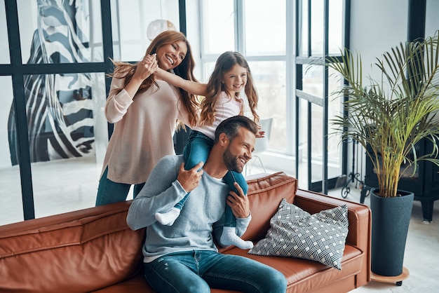 Glückliche junge Familie, die zu Hause zusammenhält