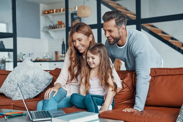 Glückliche junge Familie, die zu Hause zusammenhält