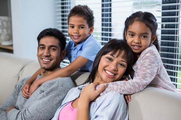 Glückliche junge Familie, die zusammen auf der Couch aufwirft