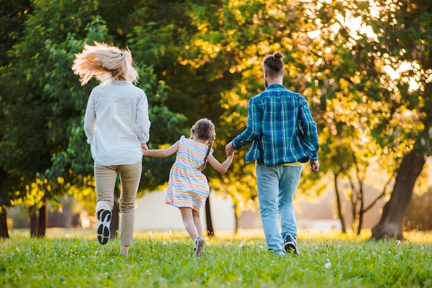 Glückliche junge familie, die zusammen zeit draußen in der grünen natur verbringt.