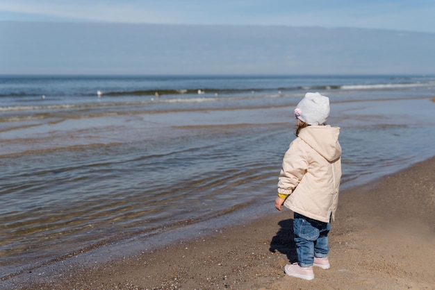 Glückliche junge Familie hat Spaß am Strandlauf und springt bei Sonnenuntergang