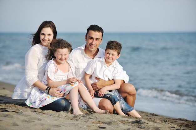 glückliche junge familie hat spaß und lebt einen gesunden lebensstil am strand