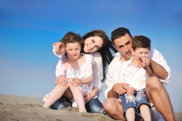 glückliche junge familie hat spaß und lebt einen gesunden lebensstil am strand