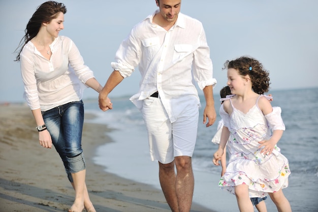 glückliche junge familie hat spaß und lebt einen gesunden lebensstil am strand